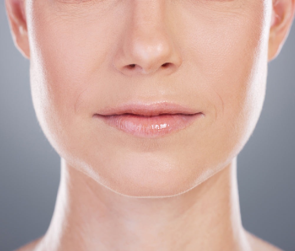 Vista frontal de la parte inferior del rostro, la mandíbula y el cuello de una mujer madura, en referencia a la armonía entre el rostro y el cuello con toxina botulínica (Nefertiti lift) y tratamientos de piel en Medellín